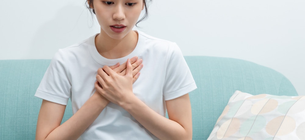 胸を押さえ、俯く女性